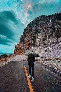 Full length rear view of man standing on road