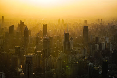 Aerial view of buildings in city at sunset