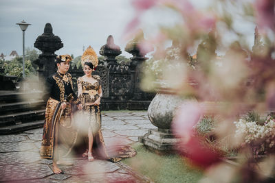 People in traditional clothing walking at temple