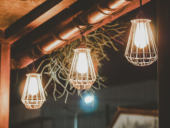 Low angle view of illuminated pendant light hanging from ceiling