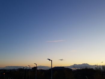 Silhouette street light against clear blue sky at sunset