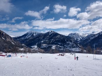 Group of people on snowcapped mountain against sky