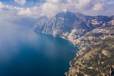 Aerial view of sea and mountains against sky