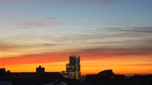 Silhouette buildings against sky during sunset