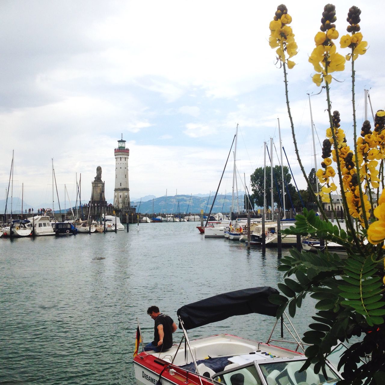 nautical vessel, transportation, water, mode of transportation, sky, cloud - sky, sailboat, nature, sea, moored, harbor, day, mast, pole, real people, plant, travel, one person, beauty in nature, outdoors, yacht