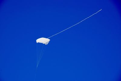 Low angle view of kite flying against blue sky