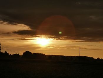 Scenic view of silhouette field against sky during sunset