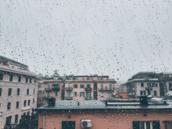 City buildings seen through wet glass window