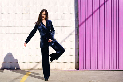 Full length of young woman against wall