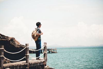 Man standing by sea against sky