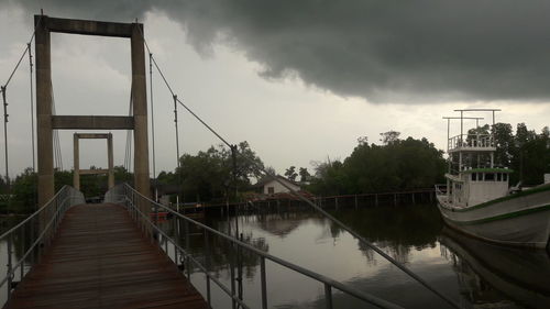 Footbridge over water against sky