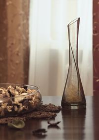 Flask by dry flowers on table