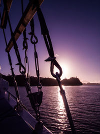 Silhouette sailboat on sea against clear sky during sunset