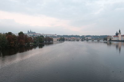 Scenic view of river by buildings against sky