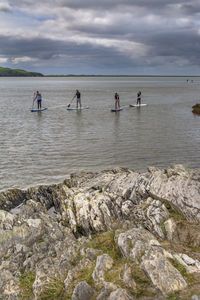 People standing on beach against sky