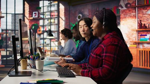 Young woman using mobile phone while standing in cafe