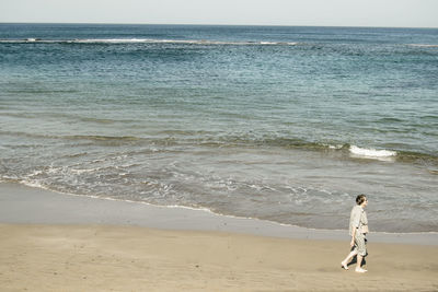 Rear view of man standing on beach