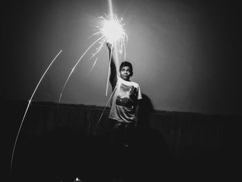 Woman holding umbrella at night