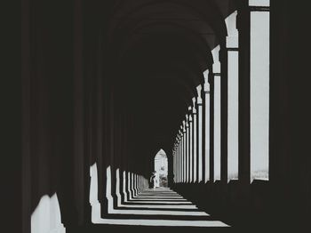 Woman walks through the portic archways up to san luca catbedral