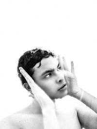 Portrait of shirtless young man against white background