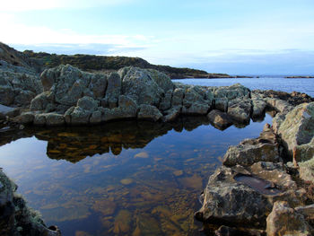 Scenic shot of calm sea with rocks in foreground