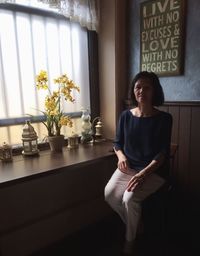 Portrait of woman sitting on seat at cafe