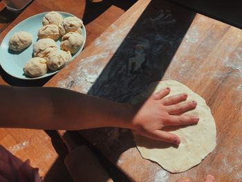 High angle view of girl preparing dough