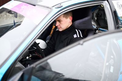 Young man wearing uniform sitting in car