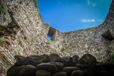 Low angle view of stone wall against sky