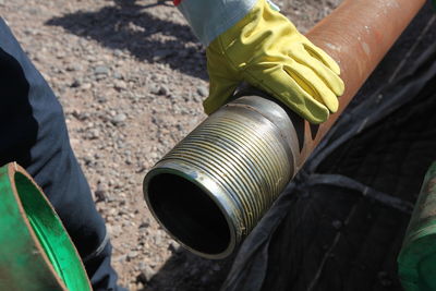 Midsection of man holding metal