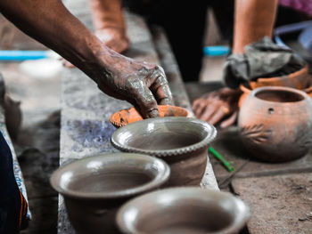 Cropped hand of man making pottery in workshop