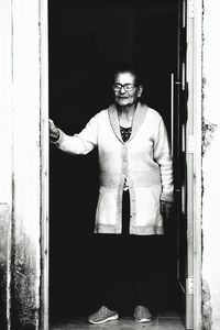 Portrait of man standing against door