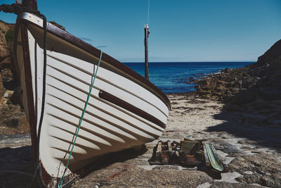 View of a boat at the beach against sky in conrwall