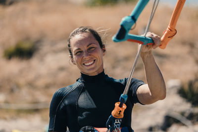 Smiling woman kitesurfing at beach on sunny day