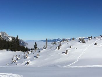 Scenic view of snow against clear blue sky