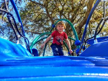 Low angle portrait of boy standing on slide