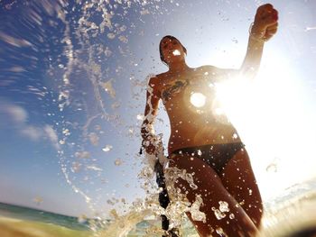 Low angle view of woman running in water