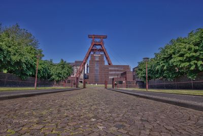 Footpath in park against blue sky