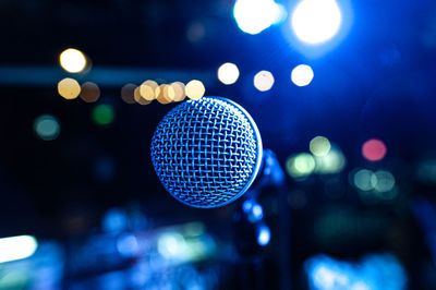 The vocalist's microphone stands on stage in the light of multicolored spotlights