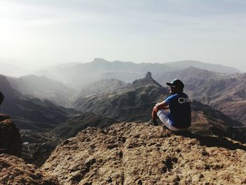 Rear view of man on mountain against sky