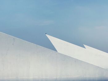 High section of building against blue sky during sunny day