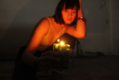 Midsection of woman holding illuminated candles