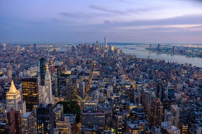 High angle view of city buildings against cloudy sky