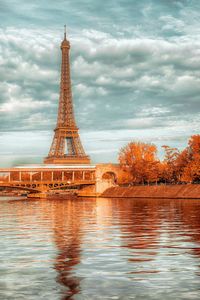 Eiffel tower by river in city