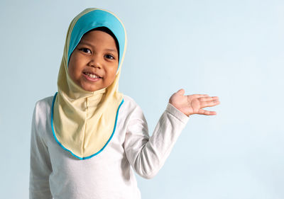 Portrait of happy boy standing against white background