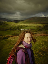 Portrait of woman standing on field against sky