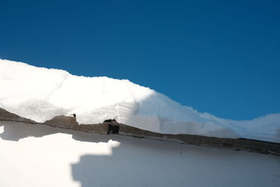 Snow covered mountain against blue sky