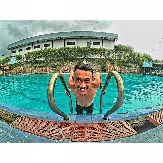 PORTRAIT OF SMILING MAN SWIMMING POOL