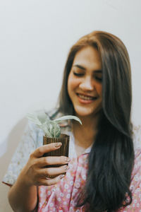 Portrait of a smiling young woman holding glass