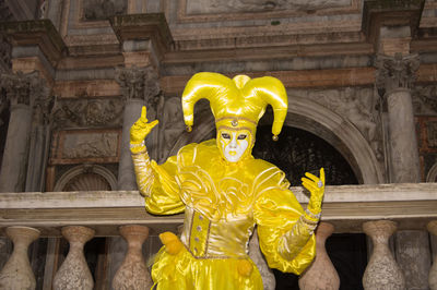 Statue against yellow wall